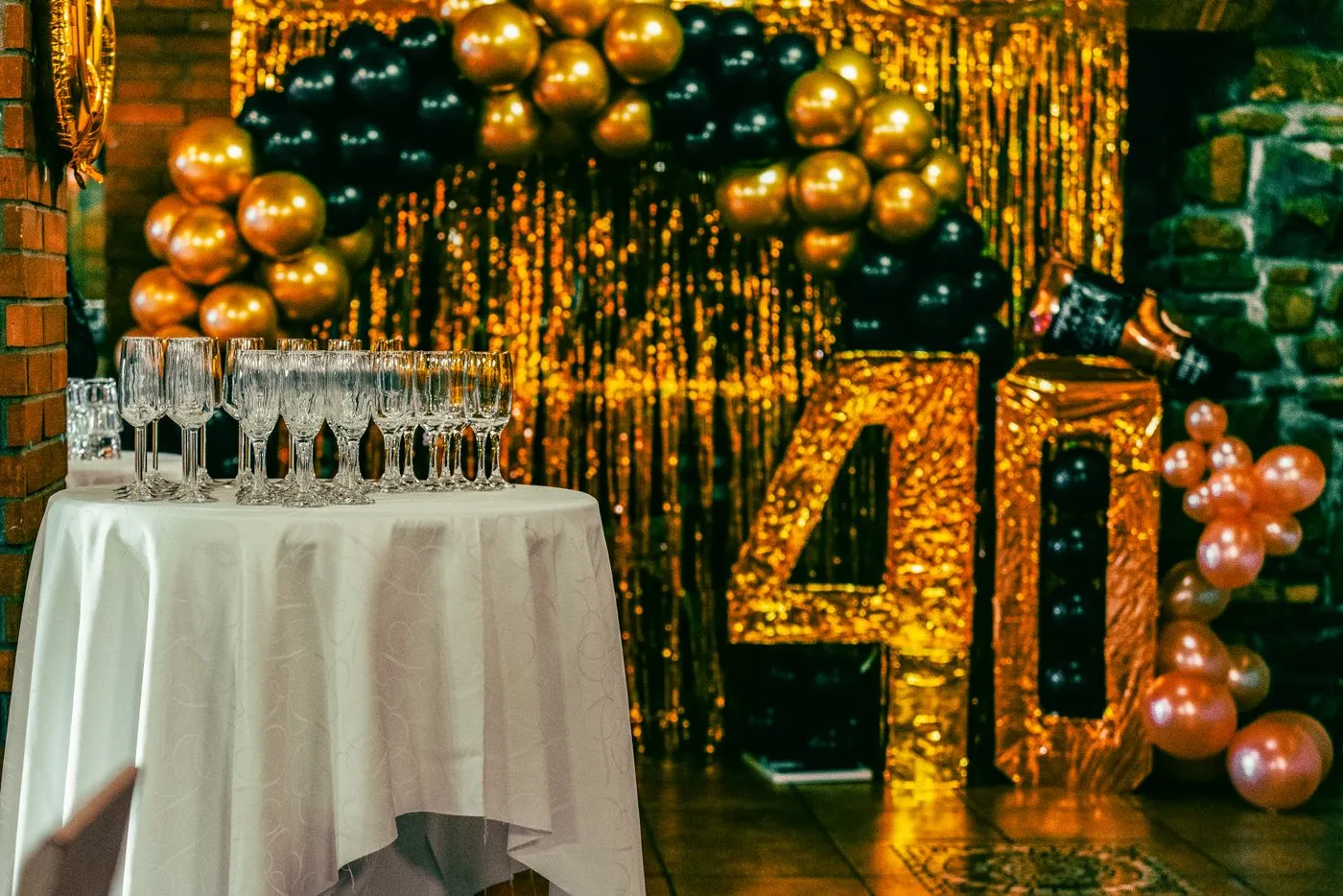 A milestone birthday venue dressed in gold with filled glasses laid out on a table