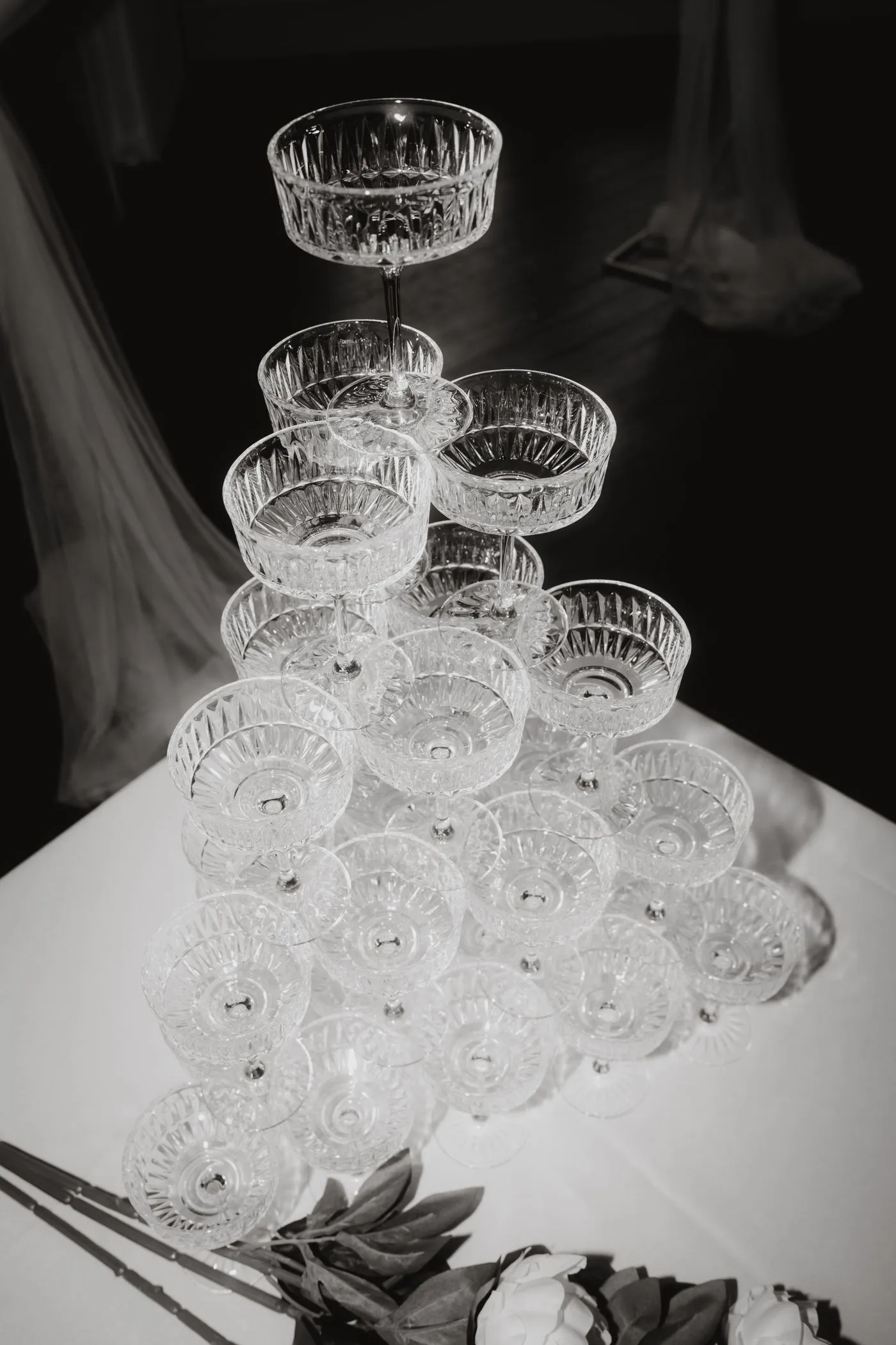 A pyramid of cut-crystal glasses stacked against a dark background at an event