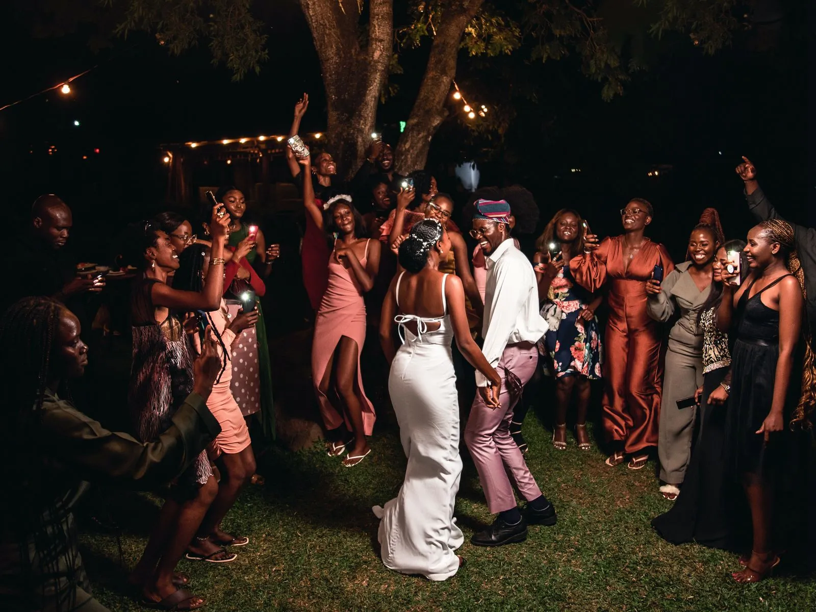 Guests dancing together at an evening celebration under warm lighting