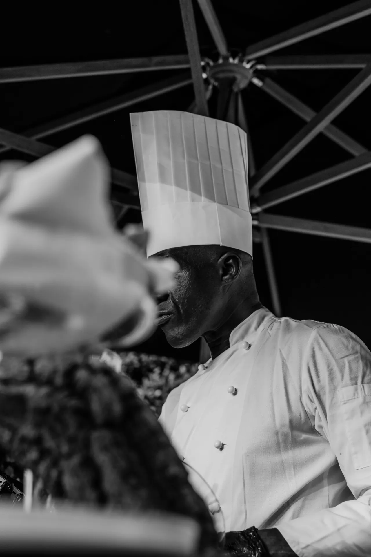 Black and white portrait of the KaizenCo chef in a tall chef’s hat and white jacket
