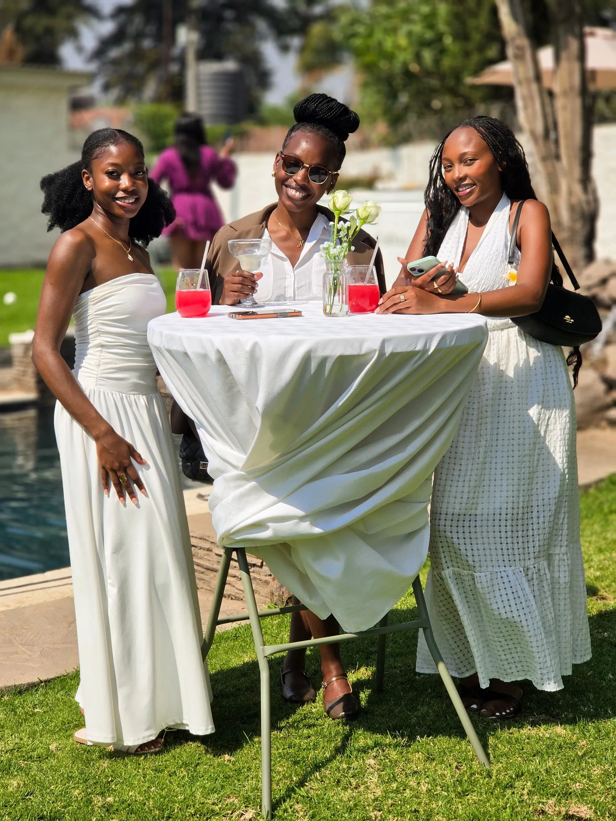 Three guests enjoying drinks around a garden cocktail table at the KaizenCo launch