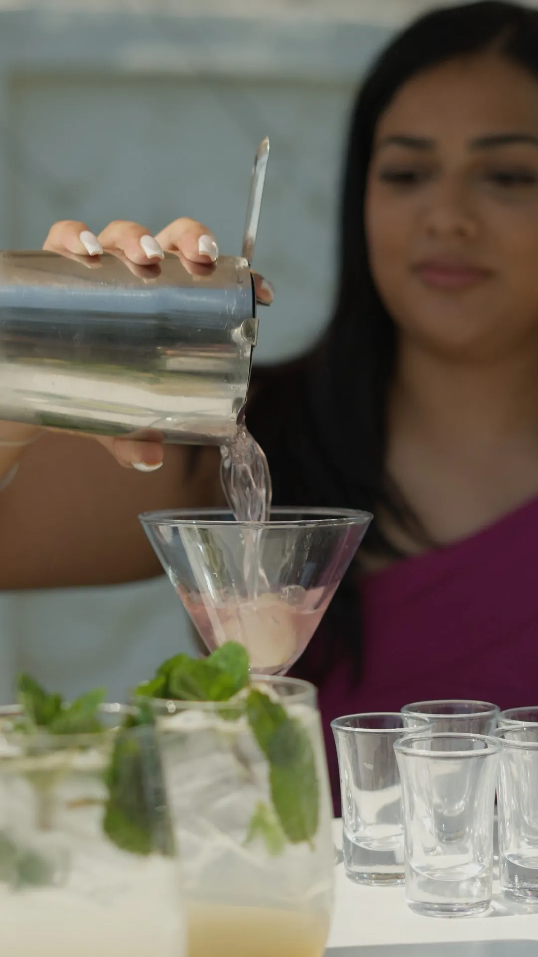 A cocktail being poured from a shaker into a stemmed glass at the KaizenCo launch
