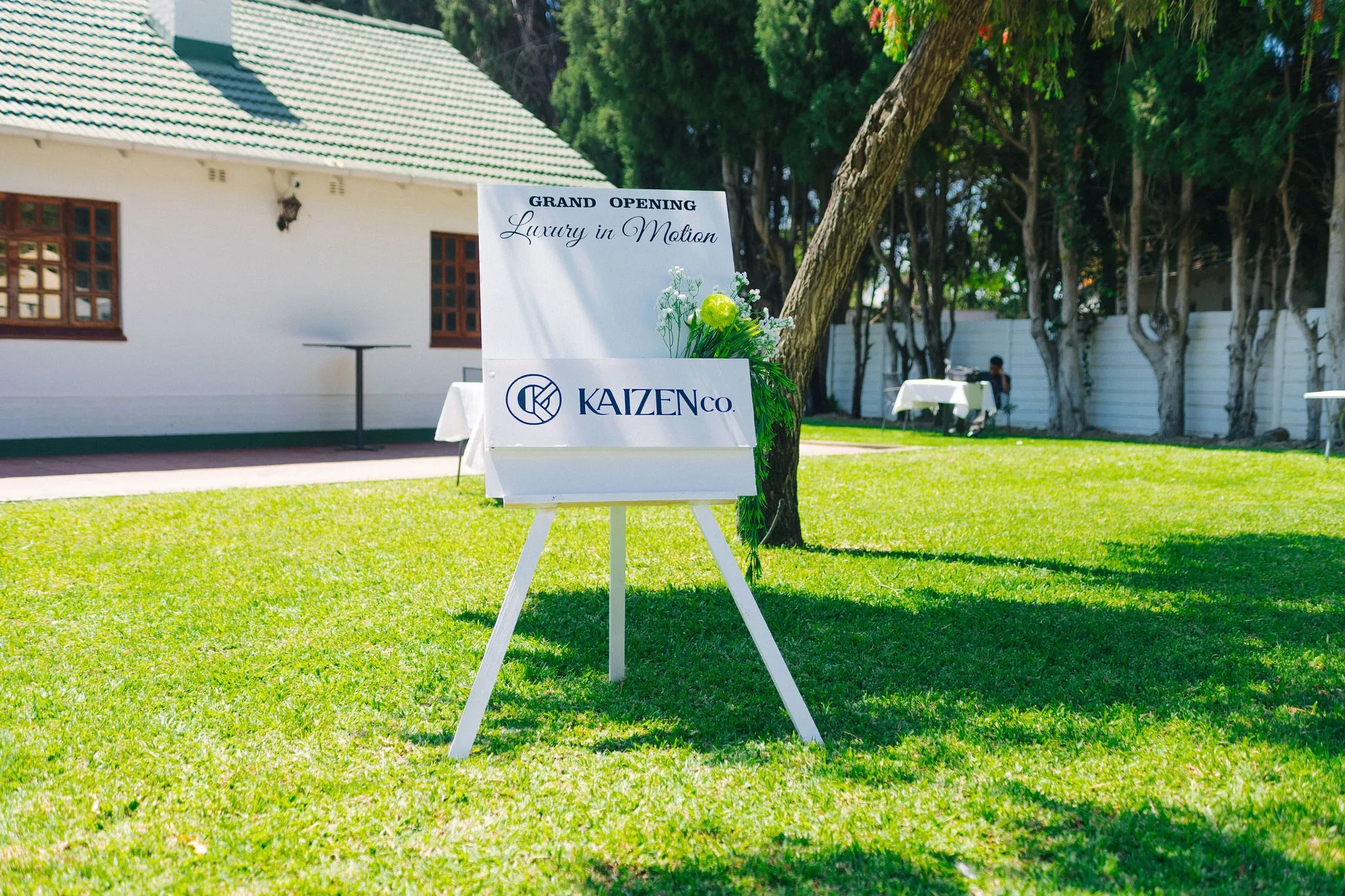 The KaizenCo grand opening welcome sign on the garden lawn